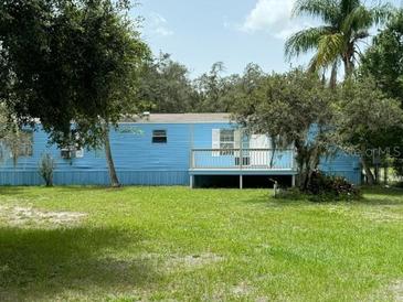 Single-wide mobile home with a blue exterior and deck at 11911 Rhodine Rd, Riverview, FL 33579