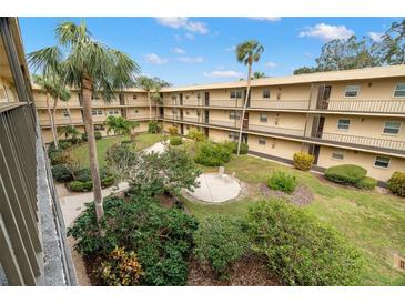 View of the building's courtyard with lush landscaping and seating area at 11485 Oakhurst Rd # 322, Largo, FL 33774