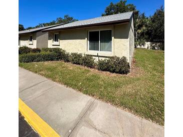 Tan house exterior with a well-manicured lawn and sidewalk at 4215 E Bay Dr # 1013B, Clearwater, FL 33764