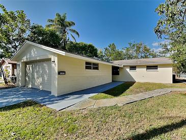 House exterior featuring a single-story home with a two-car garage and well-maintained lawn at 5301 82Nd N Ave, Pinellas Park, FL 33781