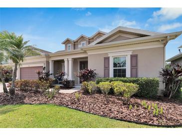 Two-story home with a landscaped yard and attached garage at 7011 Covington Stone Ave, Apollo Beach, FL 33572