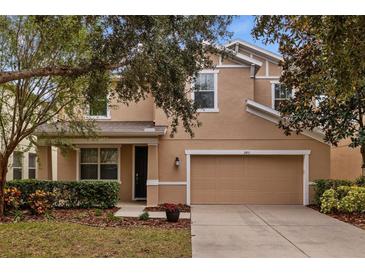 Two-story house with taupe exterior, landscaping and a two car garage at 2811 Maple Brook Loop, Lutz, FL 33558