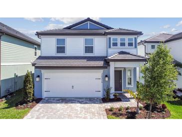 Charming two-story home featuring a two-car garage and beautifully landscaped front yard at 10316 Cross River Trl, Parrish, FL 34219