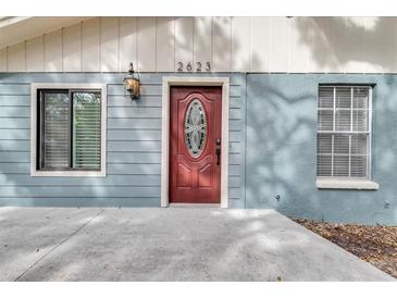 Newly renovated home featuring a light blue exterior, red door, and a concrete driveway at 2623 W Tyson Ave, Tampa, FL 33611