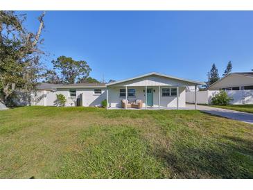 Charming ranch house with a covered porch and well-maintained lawn at 3207 Acacia St, Lutz, FL 33558