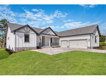Modern two-story home with three car garage and manicured lawn at 6773 Summit View Dr, Brooksville, FL 34601