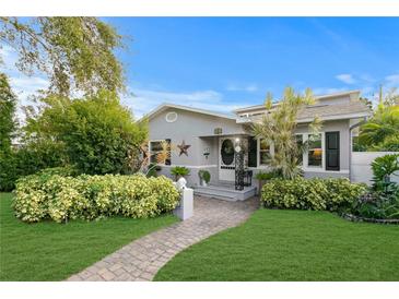 Charming home featuring lush landscaping, a brick walkway, and a welcoming front entrance at 860 25Th N Ave, St Petersburg, FL 33704