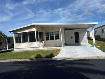 Single-story mobile home with carport and screened porch at 12501 Ulmerton Rd # 119, Largo, FL 33774