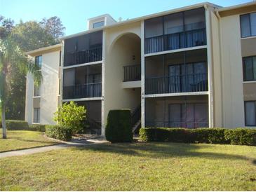 Two-story building exterior with balconies and landscaping at 3161 Lake Pine S Way # B1, Tarpon Springs, FL 34688