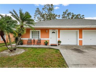 Orange duplex with a two-car garage and well-maintained lawn at 3334 W Heiter St, Tampa, FL 33607