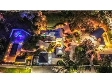 Stunning aerial view of the estate grounds and pool, illuminated beautifully at night at 518 Riverside Dr, Tarpon Springs, FL 34689