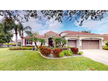 Beautiful home with stone accents, lush landscaping, and a 3-car garage at 16623 Ashton Green Dr, Lutz, FL 33558