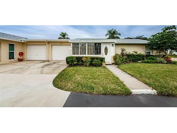 Tan house with attached garage, landscaped yard, and walkway at 2739 Sherbrooke Ln # B, Palm Harbor, FL 34684