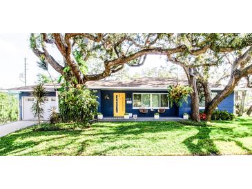 Charming ranch home with a vibrant blue exterior and yellow door at 130 63Rd S St, St Petersburg, FL 33707
