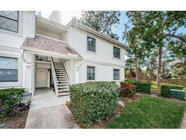 Two-story building exterior with stairs, landscaping, and a private entrance at 416 Meadow Ln, Oldsmar, FL 34677