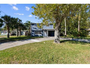 Two-story house with gray siding and a covered carport at 30 New York Ave, Dunedin, FL 34698