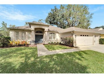 Beautiful one-story home with a landscaped yard, two-car garage, and inviting entryway at 12611 River Birch Dr, Riverview, FL 33569