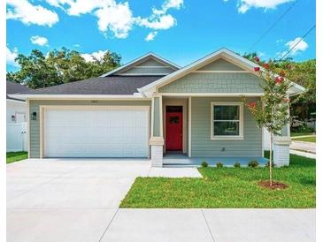 Charming craftsman style home with a red door and attached garage at 2010 Sammonds Rd, Plant City, FL 33563