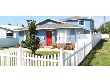 Charming blue home with red door and a white picket fence, set on a well-manicured lawn at 2918 10Th N St, St Petersburg, FL 33704