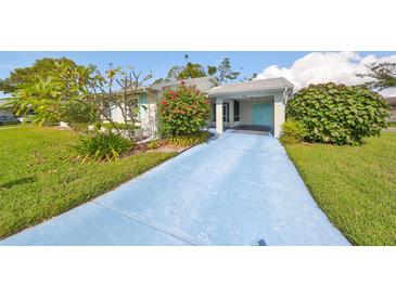 Inviting home exterior with a blue walkway and lush landscaping at 2318 Grenoble Pl, Sun City Center, FL 33573