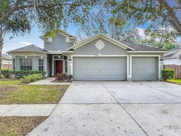 Two-story house with three car garage and manicured lawn at 4249 Balington Dr, Valrico, FL 33596