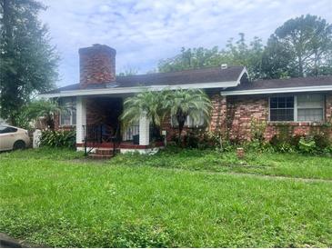 Brick house with a porch, palm trees, and a grassy lawn at 10006 N Mitchell Ave, Tampa, FL 33612