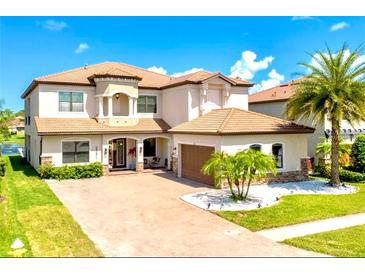 Two-story house with a three car garage, light brown roof, and landscaping at 2591 Grand Cypress Blvd, Palm Harbor, FL 34684