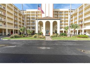 Exterior view of a multi-story building with parking and an entrance at 9000 Commodore Dr # 401, Seminole, FL 33776
