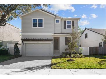 Two-story house with gray siding, a gray door, and a two-car garage at 3612 W Renellie Cir, Tampa, FL 33629