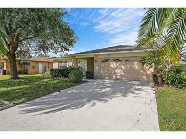 Single-story house with attached garage and landscaped lawn at 4175 103Rd N Ave, Clearwater, FL 33762