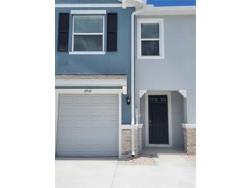 A charming two-story townhome showcasing a well-maintained facade with a garage and front door at 2472 Mellow Ln, Clearwater, FL 33765