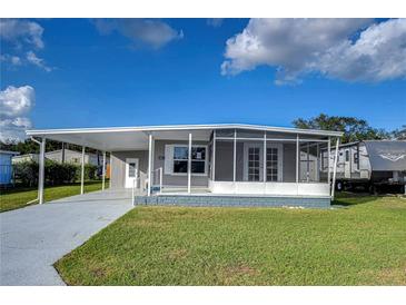 Single-wide mobile home with carport and screened porch at 39053 Flora Ave, Zephyrhills, FL 33542