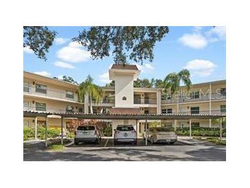 Front view of a two-story residential building with covered parking at 820 Virginia St # 207, Dunedin, FL 34698