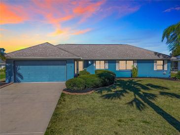 Ranch style home with blue exterior and landscaping at 1715 S Pebble Beach Blvd, Sun City Center, FL 33573