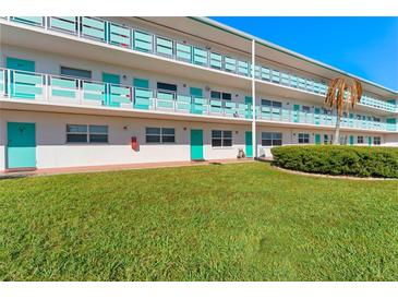 Two-story building with teal accents and a manicured lawn at 1950 59Th N Ave # 114, St Petersburg, FL 33714