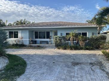 Light blue house with a paved driveway and landscaping at 8060 Gulf Blvd, St Pete Beach, FL 33706