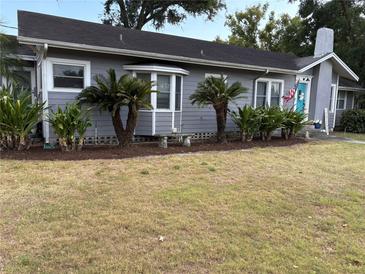 Charming single-story home with gray siding, mature landscaping, and an inviting turquoise front door at 1003 W Mahoney St, Plant City, FL 33563