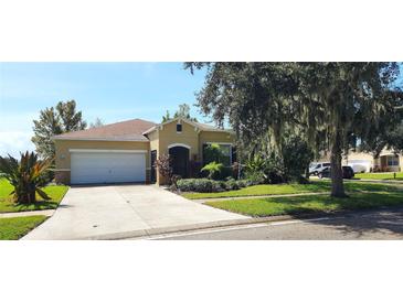 Single-story house with a two-car garage and a landscaped front yard at 107 Slipper Key Rd, Apollo Beach, FL 33572