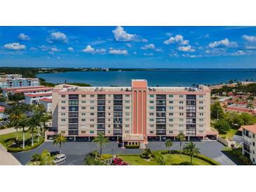 Aerial view of a waterfront condo building with parking and lush landscaping at 19029 Us Highway 19 N # 9-706, Clearwater, FL 33764