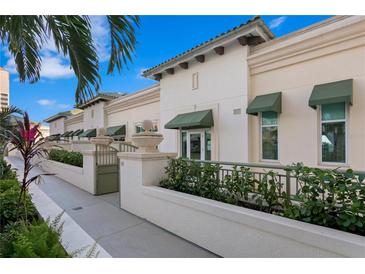 Elegant condominium exterior with lush landscaping, charming awnings, and gated entrance at 450 Knights Run Ave # 407, Tampa, FL 33602