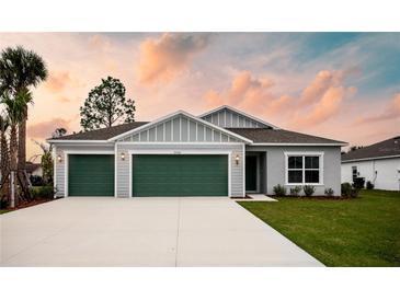 Modern two-car garage home with gray and green exterior at 25434 Colon Dr, Punta Gorda, FL 33983