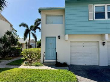 Light blue townhome exterior with a garage and palm trees at 3247 38Th S Way # E, St Petersburg, FL 33711