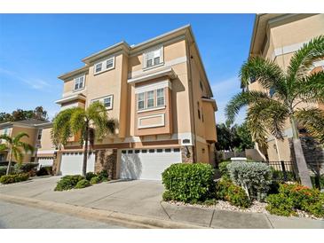 Beautiful 3 story tan townhouse with 3 car garage at 562 Rivercrest Ln, Tarpon Springs, FL 34689