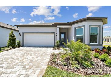 Charming one-story home with manicured lawn, paver driveway, and inviting facade at 11208 Shoreline Trl, Parrish, FL 34219