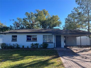 Light blue single story home with a dark gray door and paved driveway at 5411 Staley Dr, Tampa, FL 33610