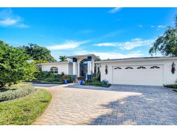 White two-story house with a three-car garage and landscaped yard at 105 Estado Ne Way, St Petersburg, FL 33704