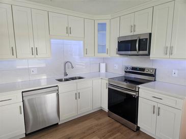 Modern kitchen with white cabinets, stainless steel appliances, and quartz countertops at 2359 Finlandia Ln # 27, Clearwater, FL 33763