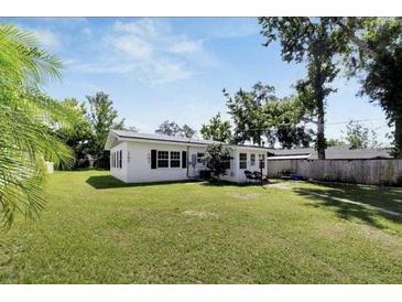 Spacious backyard featuring a well-maintained lawn and partial fencing, with a view of the home at 5121 10Th St, Zephyrhills, FL 33542