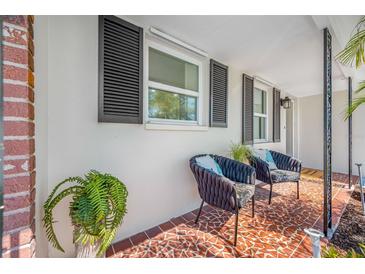 Inviting front porch with decorative chairs and terracotta tile flooring at 11211 60Th Ave, Seminole, FL 33772