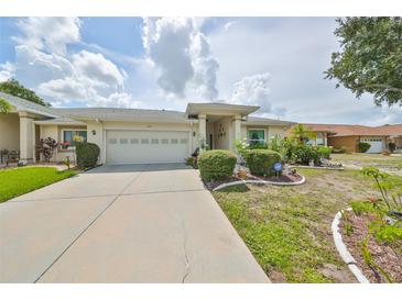 House exterior showcasing a two-car garage and well-maintained landscaping at 909 Sun Key Ct, Sun City Center, FL 33573